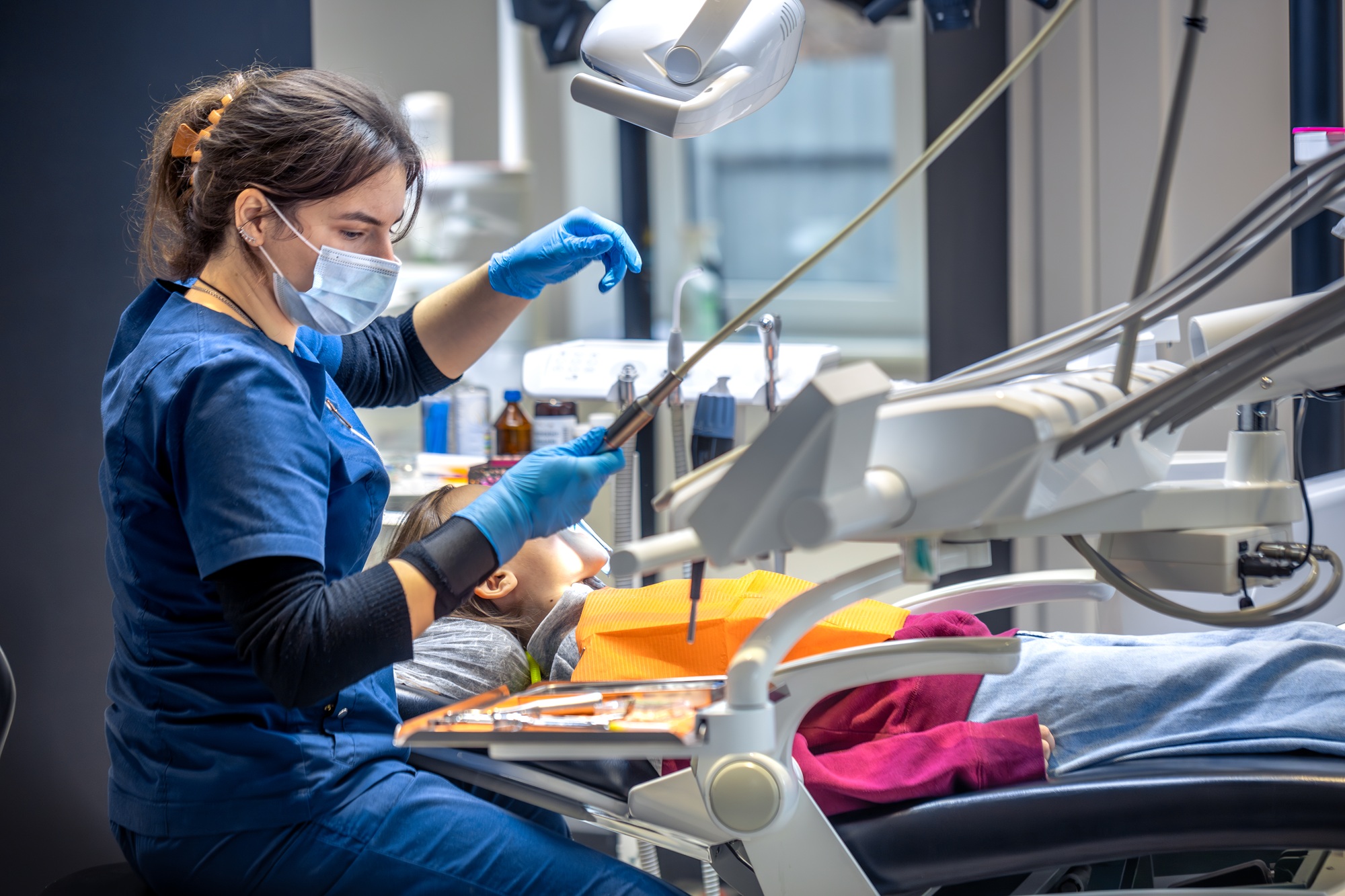 Young female dentist in dental office. Dentist at work. Dental treatment concept.